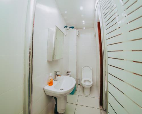 a white bathroom with a toilet and a sink at AvonHeights Apartments in Lekki Phase 1