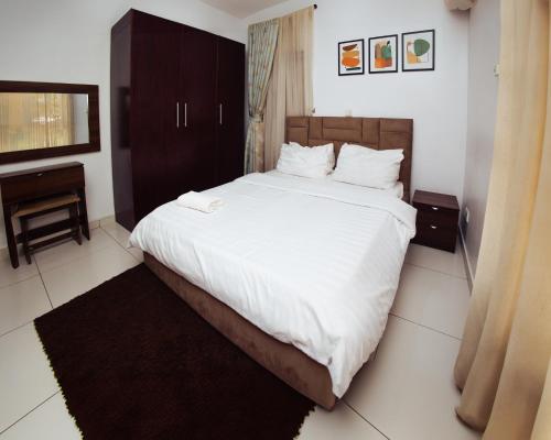a bedroom with a large bed with white sheets at AvonHeights Apartments in Lekki Phase 1