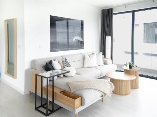 a living room with a white couch and a table at The "Perfect Suite"-top floor only of the house - views for mileskilometers! in Santo Isidoro