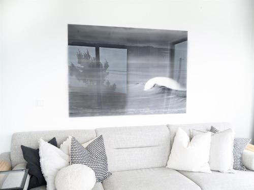 a living room with a white couch and a picture at The "Perfect Suite"-top floor only of the house - views for mileskilometers! in Santo Isidoro