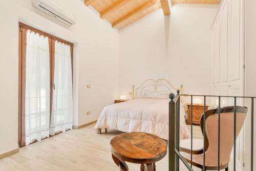 a white bedroom with a bed and a wooden table at La Casetta in Carafà in Aulla