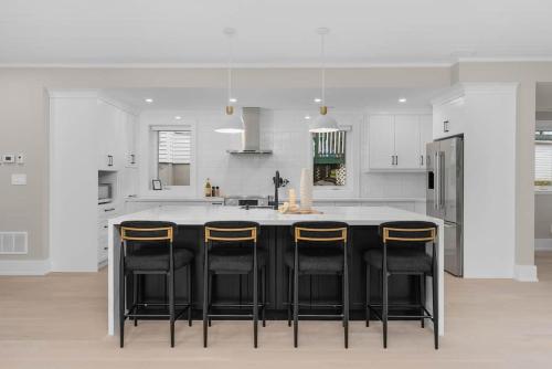 a kitchen with a black island with bar stools at charming riverside retreat in Huntsville