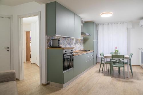 a kitchen with green cabinets and a table with chairs at Sara Home Flo in Florence