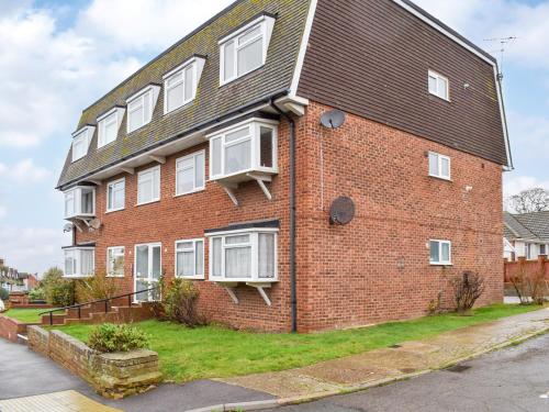 a red brick building with white windows on a street at Tankerton Heights in Whitstable