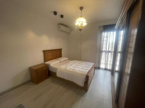 a bedroom with a bed and a large window at Pyramid View Apartment near GEM in Ghaţāţī