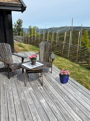 two chairs and a table on a wooden deck at Cabin With Panoramic Views Over The Mountains in Nesbyen