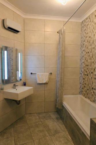 a bathroom with a sink and a bath tub at Deggies Apartments - spacious, modern apartment! in Naxxar