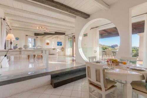 a kitchen and dining room with a table and chairs at Villa Emmeline fronte mare 5 camere 6 bagni infinity pool WiFi per 12 persone in Alghero