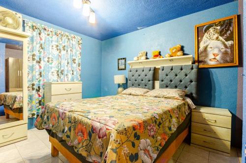 a bedroom with a bed and blue walls at Equipped house in Santa Monica 2nd Section, Qro in Adjuntas