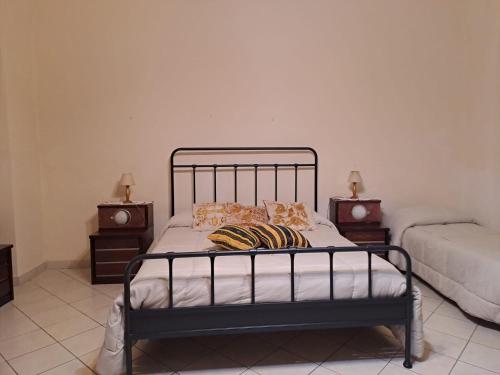 a bedroom with a metal bed with two night stands at Casa in centro a Giarre in Giarre