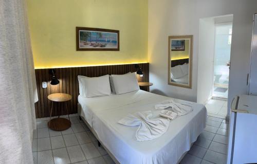 a bedroom with a bed with towels on it at Nascimento Suites in Búzios