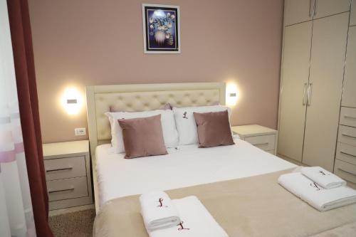 a bedroom with a large white bed with two towels at Lana's House in Berat