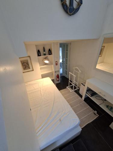a bedroom with a white bed and a desk at Quinta da Atafona in Ribeirinha