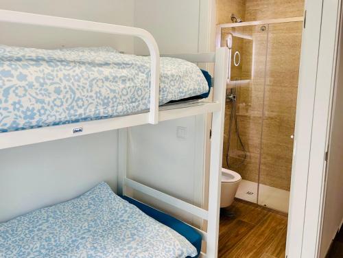 a bedroom with two bunk beds and a shower at Guest House Vasco da Gama in Lagos
