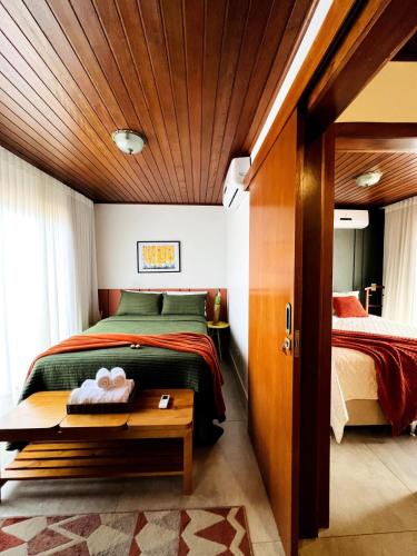 a bedroom with a bed and a wooden ceiling at Apartamento Centro de Pirenópolis Goiás in Pirenópolis