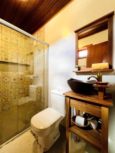 a bathroom with a toilet and a sink and a shower at Apartamento Centro de Pirenópolis Goiás in Pirenópolis