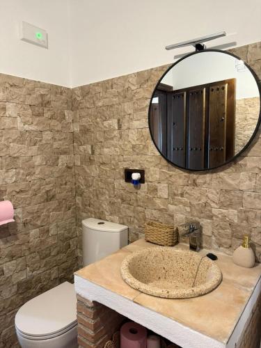 a bathroom with a sink with a toilet and a mirror at Cortijo El Nevazo II in Fuentes de Cesna