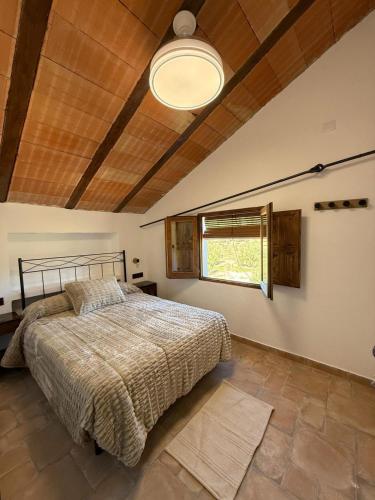 a bedroom with a large bed and a window at Cortijo El Nevazo II in Fuentes de Cesna