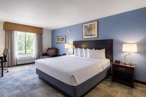 a hotel room with a large bed and a window at Greenfield Inn & Suites Owensboro, KY Airport in Owensboro
