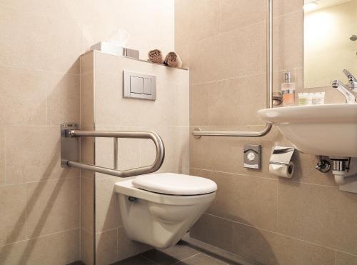 a bathroom with a toilet and a sink at Ferienhotel Bodensee in Berlingen