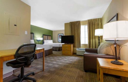 a hotel room with a desk and a room with two beds at Extended Stay America Select Suites - Atlanta - Buckhead in Atlanta