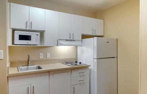 a kitchen with white cabinets and a white refrigerator at Extended Stay America Select Suites - Atlanta - Buckhead in Atlanta