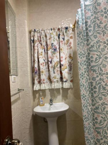 a bathroom with a sink and a shower curtain at Hospedaje Antonela in Manta