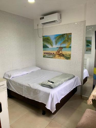 a small bedroom with a bed with a air conditioner at Hospedaje Antonela in Manta