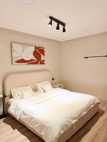 a bedroom with a large white bed with white sheets at شقة غرفة وصالة in Al Khobar