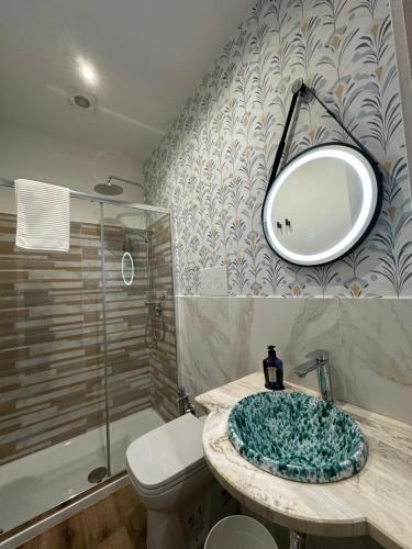 a bathroom with a sink and a toilet and a mirror at Almía apartment in Cinisi