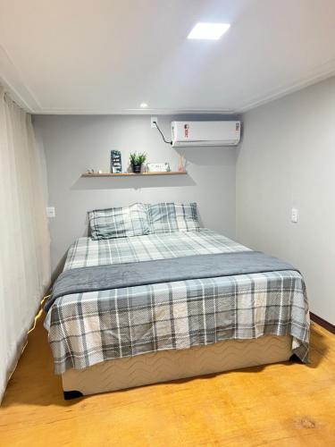 a bedroom with a bed with a plaid blanket at Apt estiloso 03 in Paragominas
