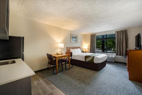 a hotel room with a bed and a table at Suburban Studios Canon City in Canon City