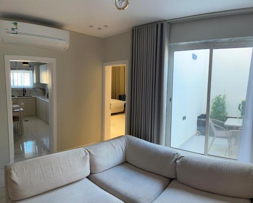 a living room with a white couch in front of a window at Rfaa Suites in Medina