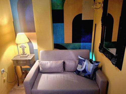 a couch in a living room with a painting at SuiteArtate in Patra