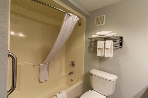 a bathroom with a shower and a toilet and towels at Greenfield Inn & Suites Owensboro, KY Airport in Owensboro