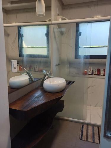 a bathroom with two sinks and a shower at Casa ampla e completa para você e sua família in Soledade de Minas