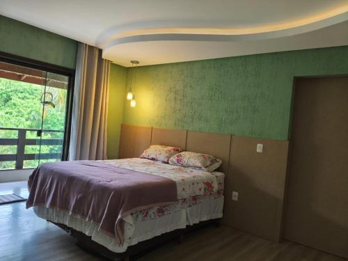 a bedroom with a bed and a green wall at Casa ampla e completa para você e sua família in Soledade de Minas