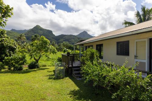 a house with a garden and mountains in the background at Hidden Haven - Group Retreat-Sleeps 7 aircon & free Wifi in Rarotonga