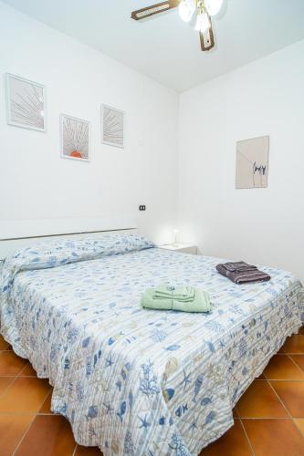 a bedroom with a bed with a blue and white comforter at Relax Between Cinque Terre and Portofino in Moneglia