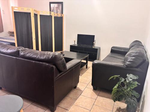 a living room with two leather couches and a table at Casa amplia in Ciudad Juárez