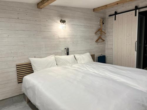 a large white bed with white sheets and pillows at Private Stay HANARE in Shishikui