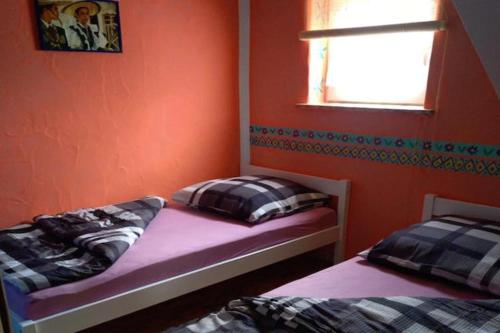 two beds in a bedroom with an orange wall at Mexican-style holiday homes in Debina