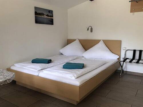 a bed with two pillows on it in a room at Bernsteinsee Home and Ferien Small Forest Chalet in Sassenburg