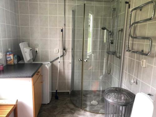 a bathroom with a shower with a glass door at Charming Red Farmhouse Near Forsheda in Krokom
