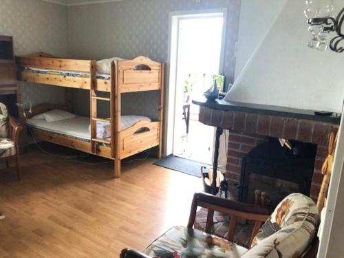 a living room with a bunk bed and a fireplace at Charming Red Farmhouse Near Forsheda in Krokom
