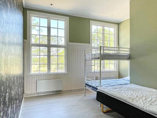 a bedroom with two bunk beds and two windows at 9 person holiday home in Mörlunda-By Traum in Mörlunda