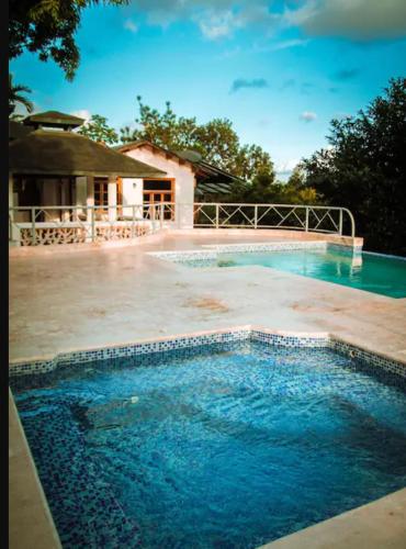 a swimming pool with blue water in front of a house at Acogedorapartamento entre montañas in Pedro Brand