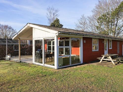 a screened in porch of a house with a picnic table at 4 person holiday home in Hals-By Traum in Hals