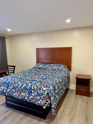 a bedroom with a bed with a floral bedspread at James Motel in Saugus
