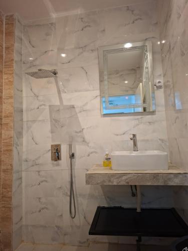 a bathroom with a sink and a shower at Hôtel Résidence Ngary in Thiès